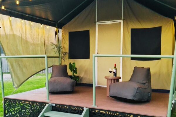 Image of a large glamping tent with a deck with chairs
